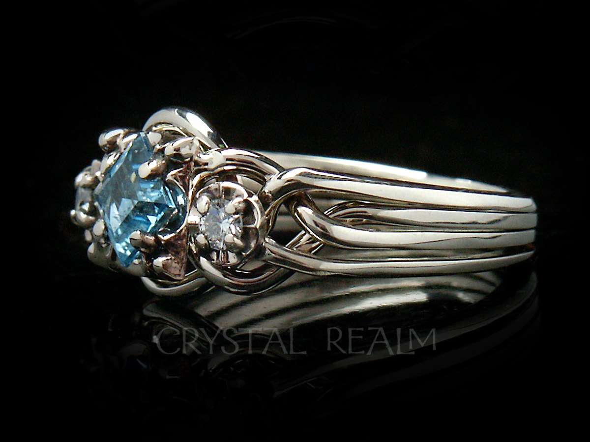 Guinevere puzzle ring in four bands with blue topaz center stone and side diamonds