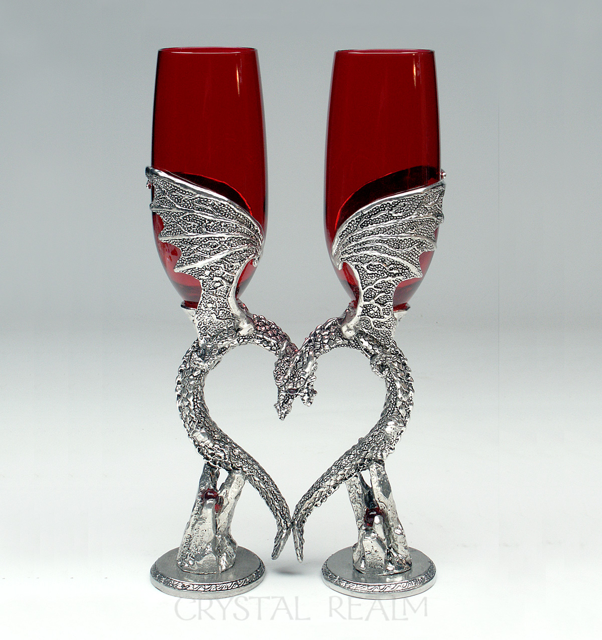 Ruby red toasting glasses held by dragons forming a heart