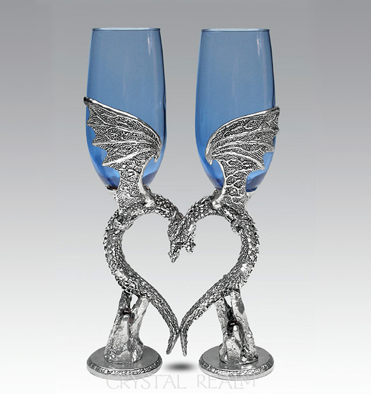 Blue champagne glasses are held by winged dragons in pewter forming a heart when at rest